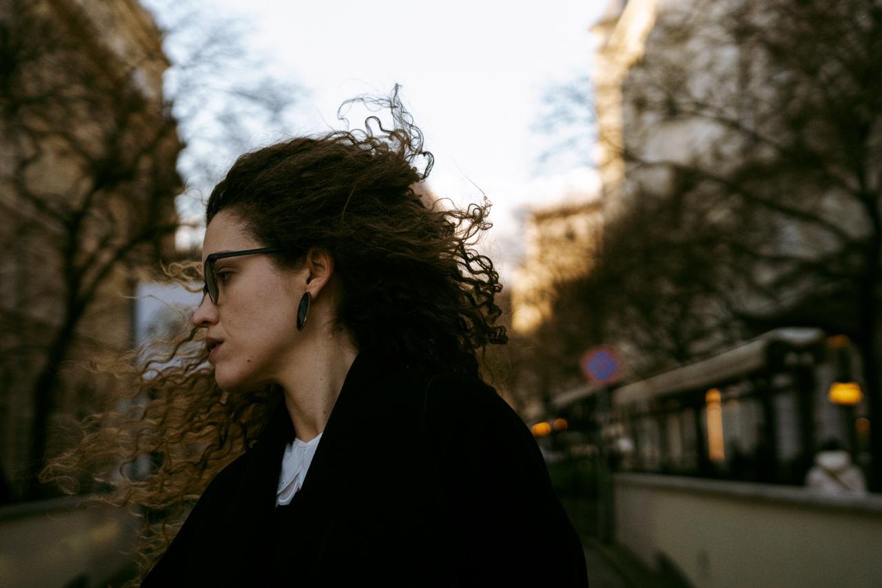A woman with curly hair in profile, the wind in her hair